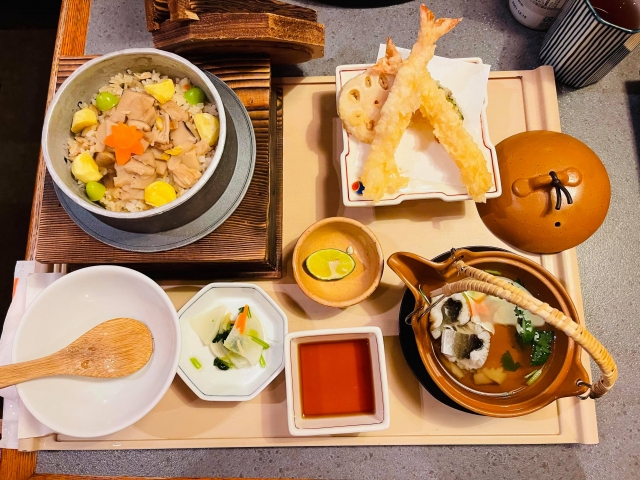 A Japanese autumn feast featuring Matsutake rice, tempura, and Dobin Mushi, beautifully arranged on a traditional tray