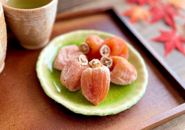 Japanese dried persimmons, or Hoshigaki, beautifully arranged on a green ceramic plate