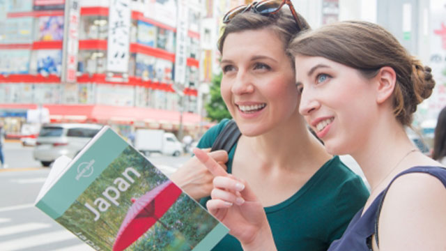 Tourists exploring Tokyo with Japan travel guide.